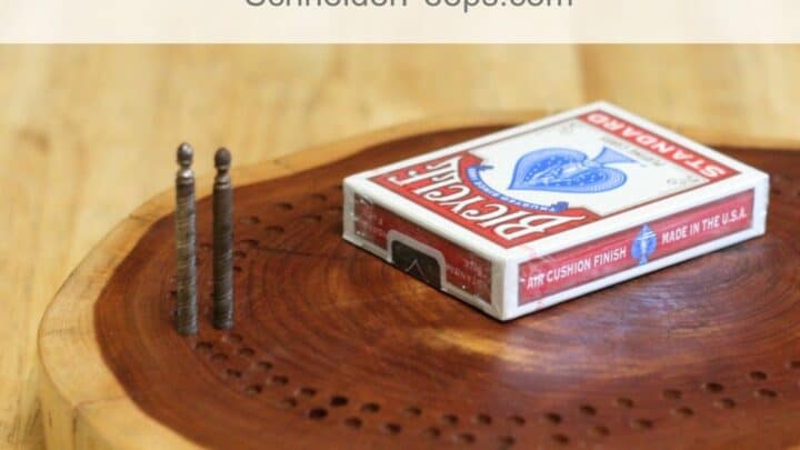 wooden cribbage board with a deck of cards on it