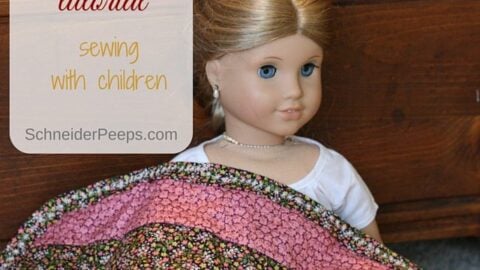 closeup of a doll quilt and a doll
