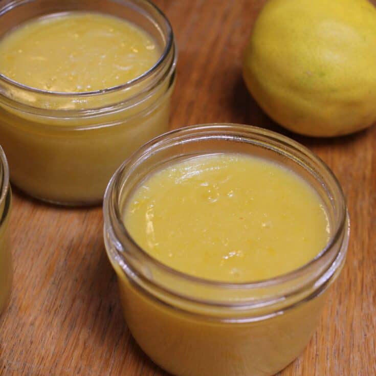 three small mason jars of meyer lemon curd on wooden table