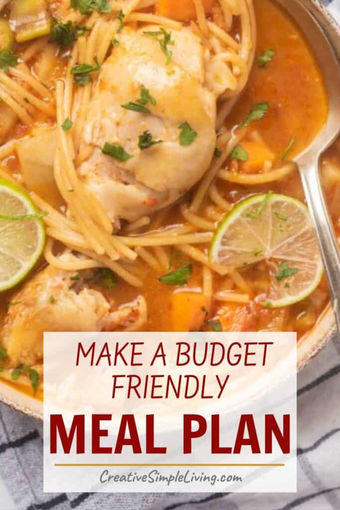 A bowl of chicken noodle soup with lime slices and herbs, next to a spoon. Overlaid text reads: “Make a budget friendly meal plan with smart meal planning. CreativeSimpleLiving.com.”.