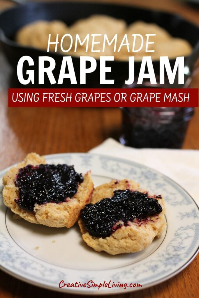 Two biscuits topped with homemade grape jam on a floral plate, with more grape jam in a jar and additional biscuits in the background. Text overlay reads, “Homemade Grape Jam using fresh grapes or grape mash.”.