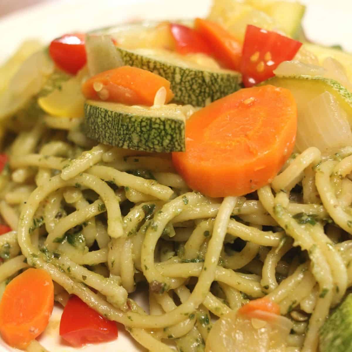 pesto pasta with carrots, squash, zucchini, onions and tomatoes
