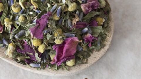 A bowl filled with a colorful blend of dried herbs and flowers, including chamomile, rose petals, and lavender. The "mountain rose herbs" logo is visible at the bottom of the image.