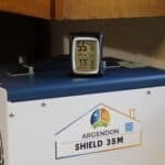 AcuRite digital hygrometer sitting on top of an Argendon Shield 35M dehumidifier displaying 55% humidity and 77 degrees.